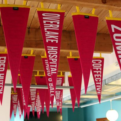 Dozens of penant flags with the names of Mentor Creative Group clients hanging from the office ceiling