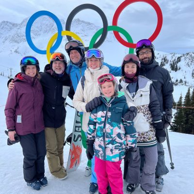 Mentor Creative Group coworkers and family members posing in front of Olympics Sign in ski gear at Whistler BC